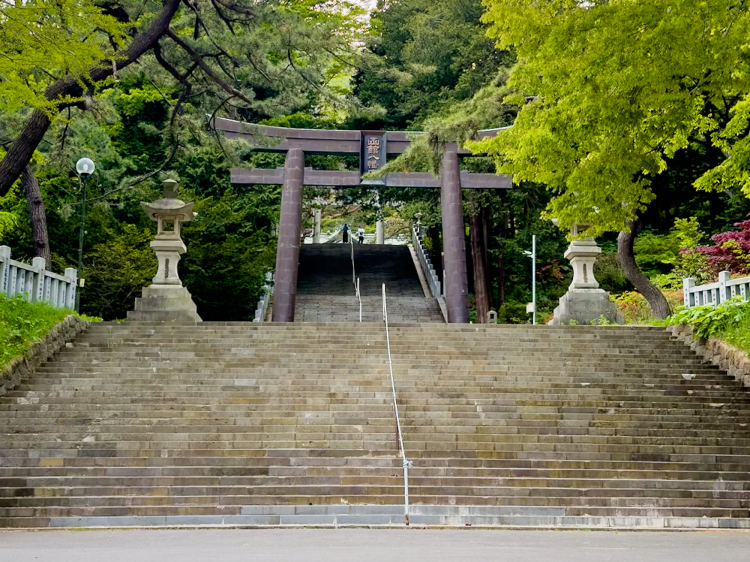 Un lourd relief du « Sanctuaire Hakodate Hachiman » est affiché sur la deuxième porte torii devant les escaliers menant au bâtiment du sanctuaire.