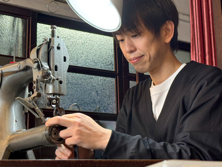 OZIO assure également la maintenance des produits. Le regard sérieux dans les yeux de M. Motobu alors qu'il se dirige vers sa machine à coudre pour la réparer montre son approche sincère de la fabrication.