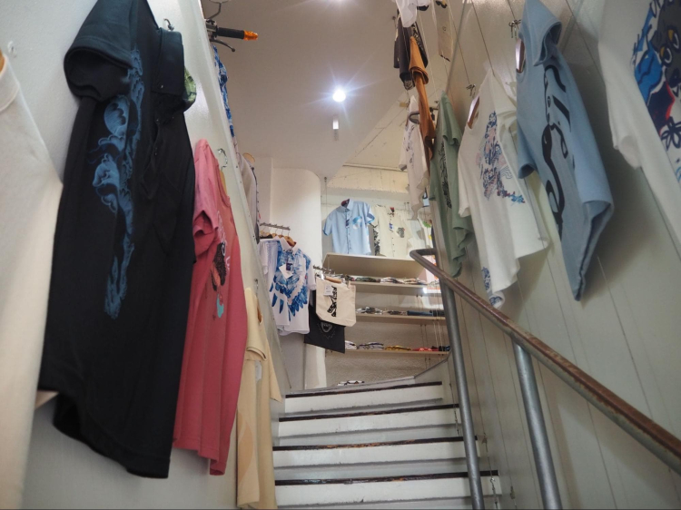 Des T-shirts aux motifs variés sont alignés dans les escaliers.