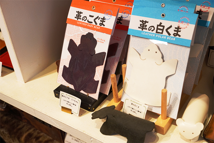 Versions en cuir des « ours sculptés en bois » qui peuvent tenir debout tout seuls, « Leather Little Bear Ku-chan (à gauche) » et « Leather Polar Bear (à droite). » Vous pouvez choisir parmi une variété de couleurs pour Ku-chan, notamment le noir, le chocolat, le marron, le rouge et l'olive.