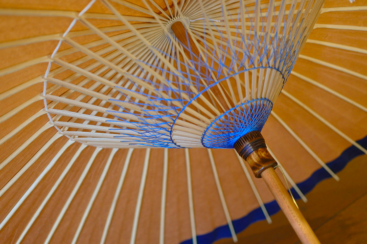 Coutures en fil qui colorent l'intérieur des parapluies japonais, chacun avec un design différent