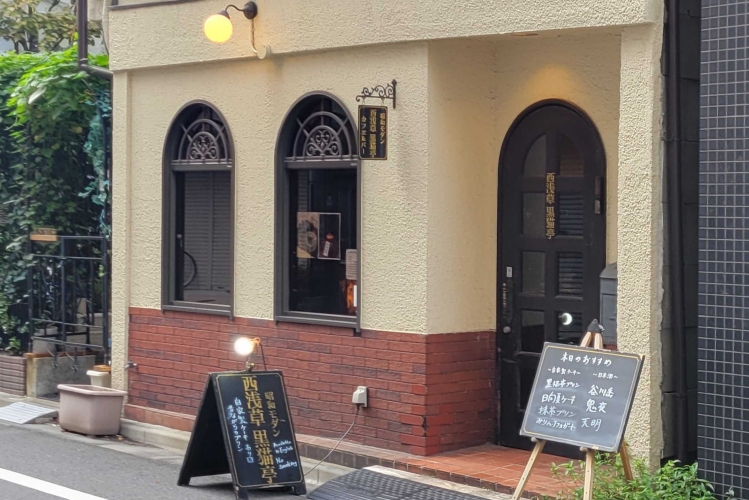 L'enseigne «&nbsp;Nishi-Asakusa Kuroneko-tei&nbsp;» se fond dans le paysage urbain de Nishi-Asakusa. Son écriture manuscrite lui confère une atmosphère particulière.