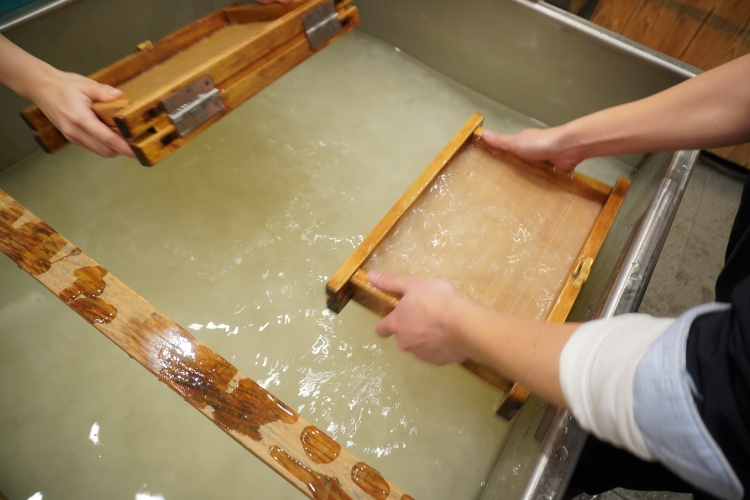 Étape du processus de coulée. L'eau mélangée aux matières premières est puisée en profondeur et les fibres s'enchevêtrent.