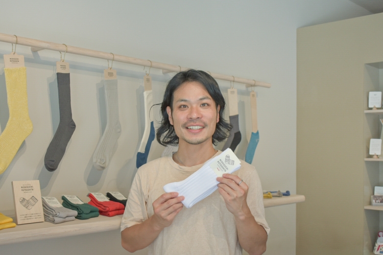 Mme Nishiguchi tient les « chaussettes égyptiennes en coton côtelé », une paire de chaussettes classiques caractérisées par leur élasticité unique.