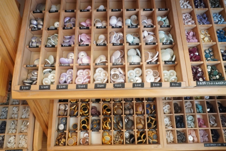 Un large choix de boutons recouverts de tissu est disponible, notamment des modèles en tweed et à motifs imitation bois.