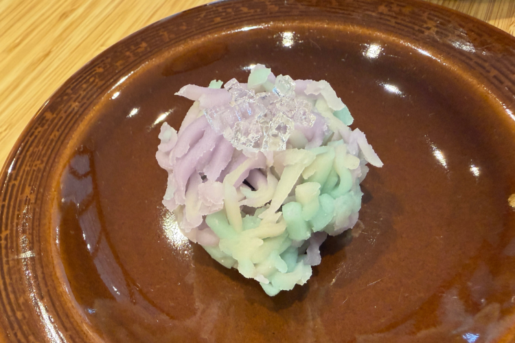 Une pâtisserie japonaise traditionnelle, reflétant les couleurs de la saison, est servie avec le thé.